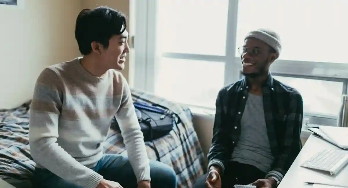 men chatting in a dormitory room