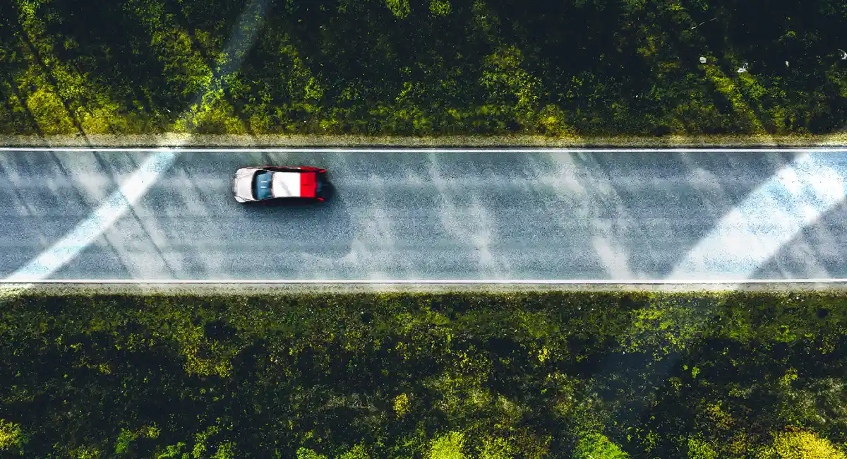 Overhead view of a car driving on a road