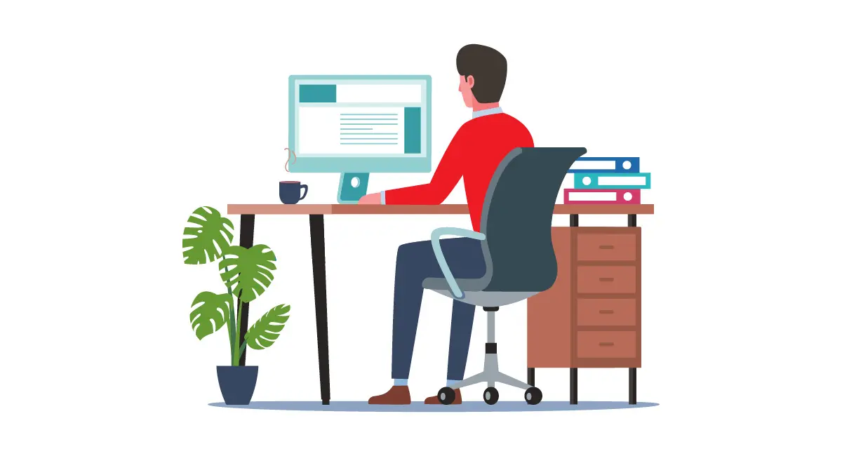 A man sitting at a desk working on a computer in a modern office with a potted plant.